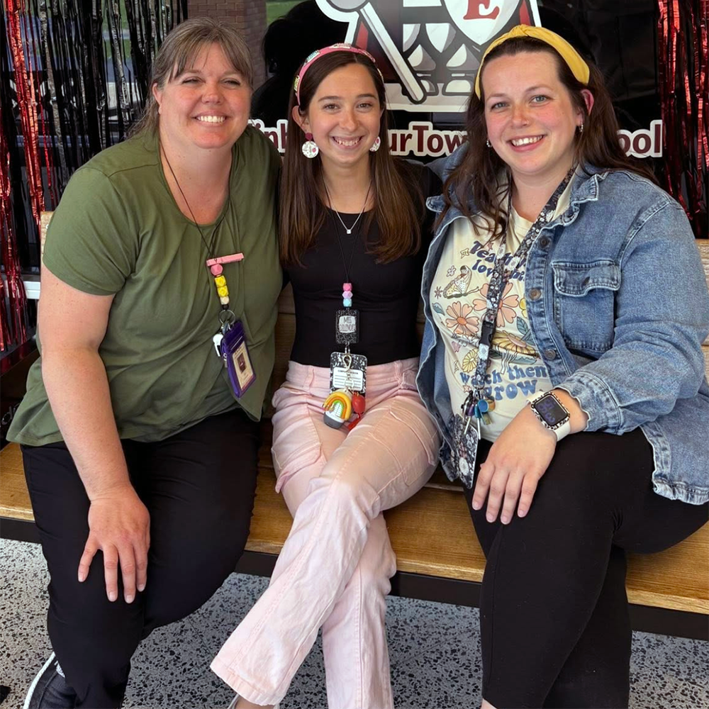Teachers sitting with student.