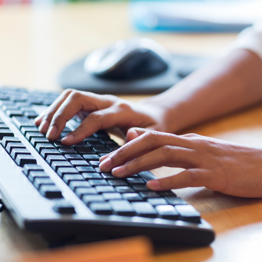 Woman typing on a computer keyboard